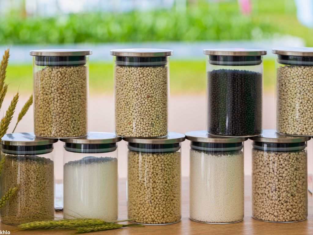 Chemical fertilizers in glass jars on a blurred background